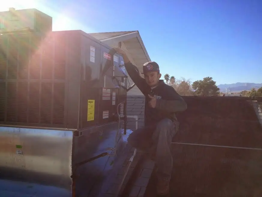 HVAC technician performing HVAC Inspection on a rooftop unit in Mooresville